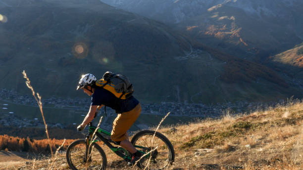 istock Mountain biker rides along grassy mountain ridge 1330399296