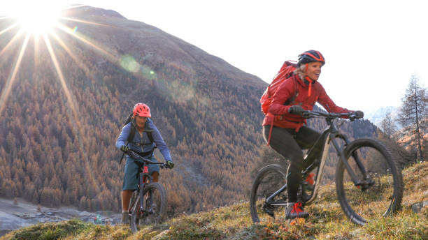 istock Mountain biking couple ride through grassy meadow 1330399863