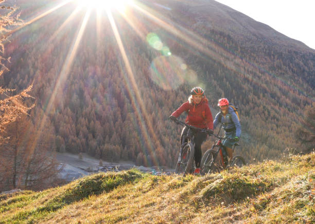 istock Mountain biking couple ride through grassy meadow 1330399874