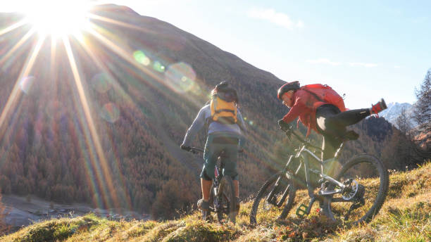 istock Mountain biking couple ride through grassy meadow 1330399883