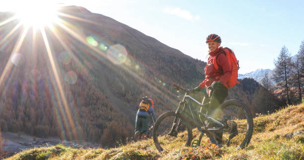 istock Mountain biking couple ride through grassy meadow 1330399907