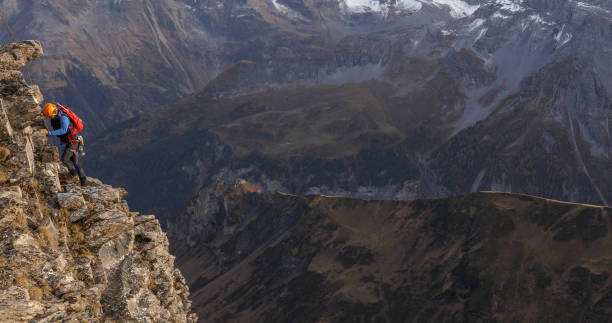 istock Mountain climber ascends mountain ridge, to the peak 1330400118