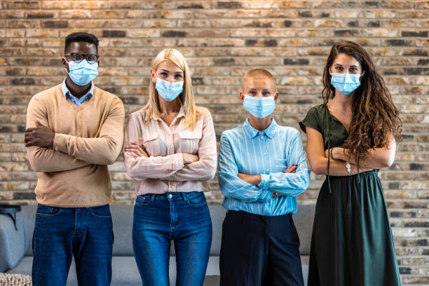 istock Four Business persons with protective masks standing side by side 1330401008