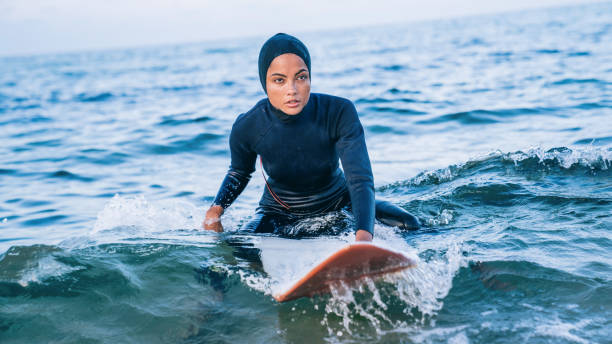 istock Female surfer with hijab in sea 1330401263