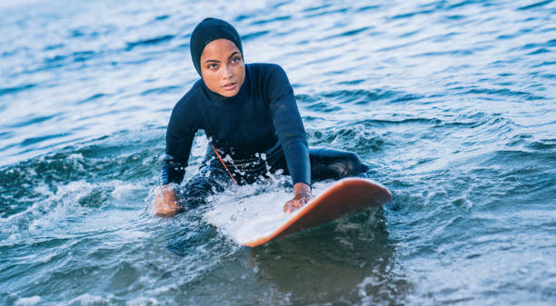 istock Female surfer with hijab in sea 1330401269