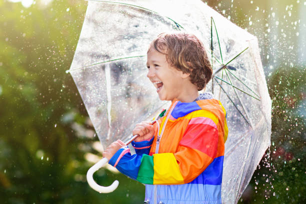 istock Child playing in autumn rain. Kid with umbrella. 1330402231