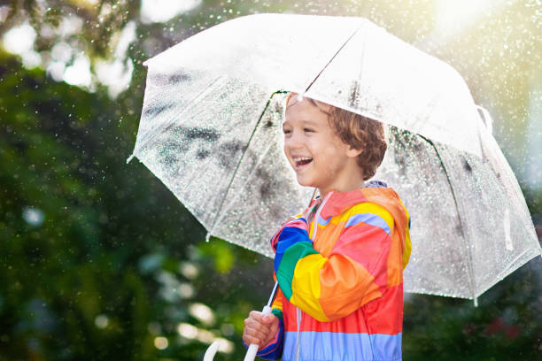 istock Child playing in autumn rain. Kid with umbrella. 1330402361