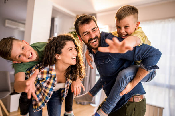 Playful family having fun at home. Playful two parents playing with their two boys in their new apartment. mum new boyfriend stock pictures, royalty-free photos & images