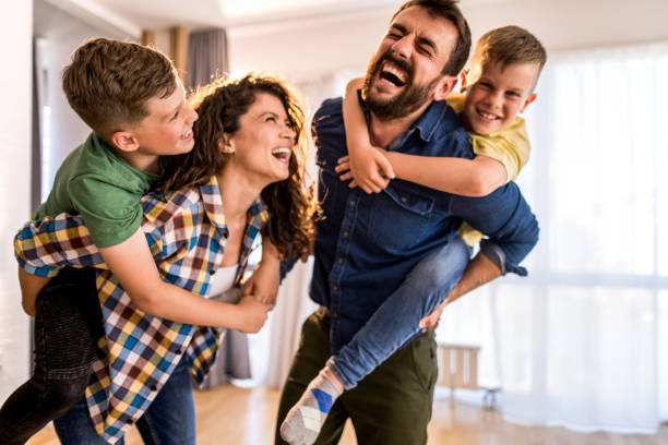 Playful family having fun at home. Playful two parents playing with their two boys and laughing. mum new boyfriend stock pictures, royalty-free photos & images