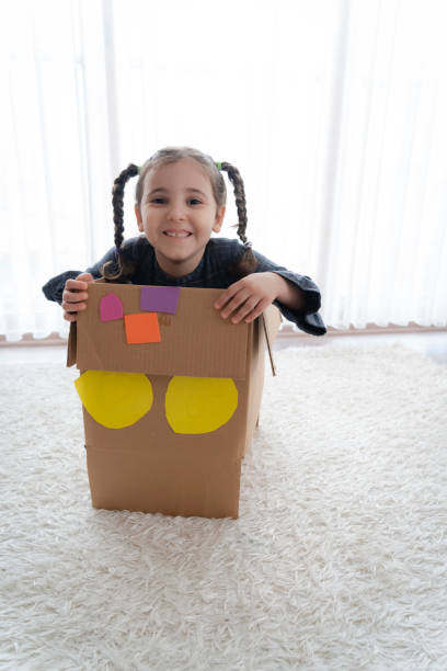 istock Little girl having fun with cardboard box 1330404213