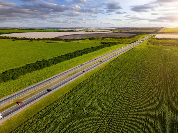 istock Aerial view of a highway going through agricultural fields at sunset 1330405667