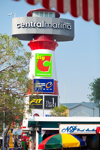 Lighthouse tower with banners outside of CentralPlaza Mall in Pattaya. Below and around is market in front of mall