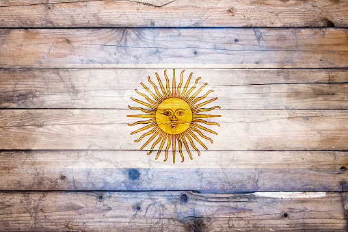 Flag of Argentina watercolor painted on a old wooden boards. Grunge flags texture. Background concept. Full color. Horizontal orientation. Faded effect.