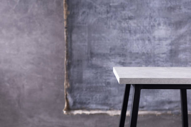 istock Table or metal stool and abstract painted canvas near concrete wall background. Tabletop or shelf 1330410564