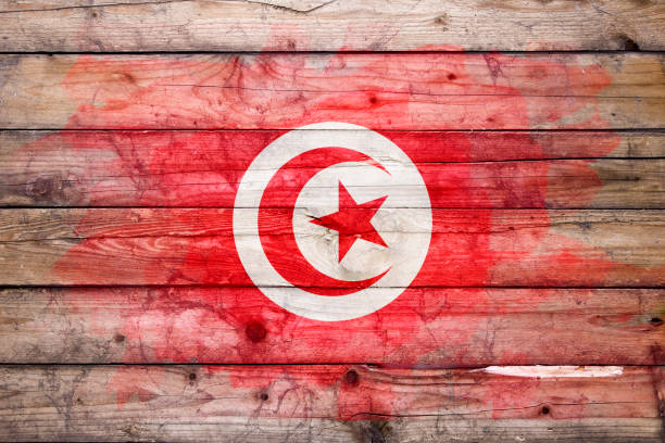 Flag of Tunisia watercolor painted on a old wooden boards. Grunge flags texture. Background concept. Full color. Horizontal orientation. Faded effect.