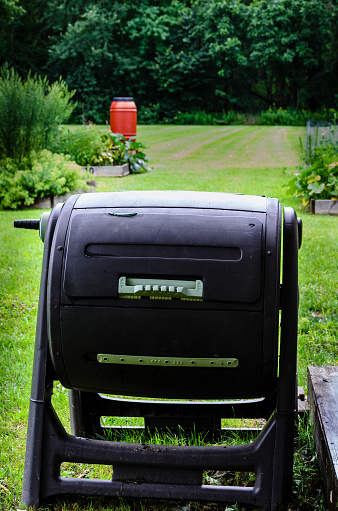 Close-up of a drum composter in a community garden
