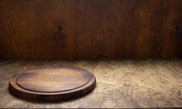 istock Pizza cutting board for homemade bread cooking or baking on table. Empty pizza board at wooden tabletop background 1330416952