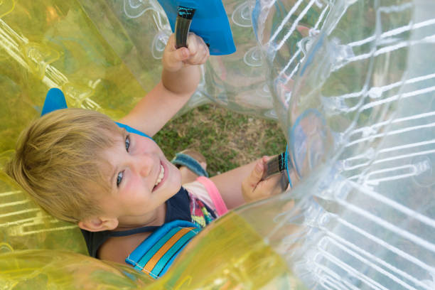 A child in a bumperball. Portrait of a happy laughing child. Happiness, fun and laughter A child in a bumperball. Portrait of a happy laughing child. Happiness, fun and laughter. zorb ball stock pictures, royalty-free photos & images