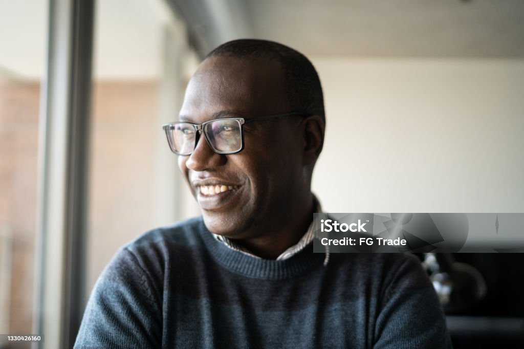 Happy mature man contemplating at home African-American Ethnicity Stock Photo
