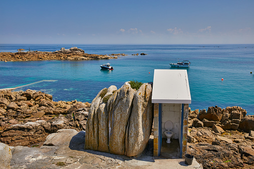 Panoramic image of from Les Minquiers, Ile Maitre Island to the East with a clear blue sky and calm sea.  The public toilet is the furthest South toilet in the British Isles. Jersey CI