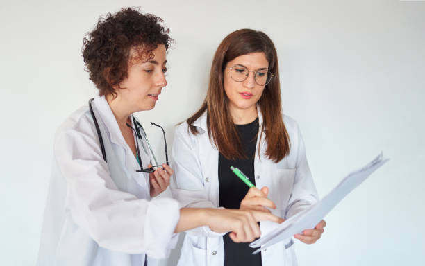 istock Two female doctors look at documents and discuss a diagnosis 1330436640