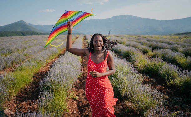 istock Woman running with a kite on a meadow at sunset 1330438245