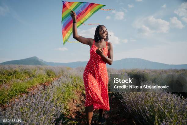 Woman Running With A Kite On A Meadow At Sunset Stock Photo - Download Image Now - Kite - Toy, Flying, One Woman Only