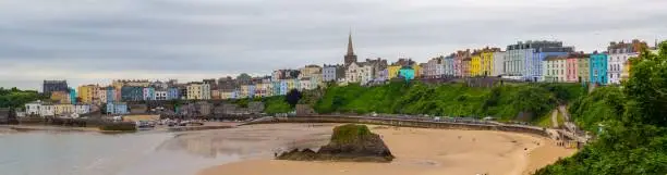 Tenby North Beach with colourful clifftop buildings and harbour at low tide