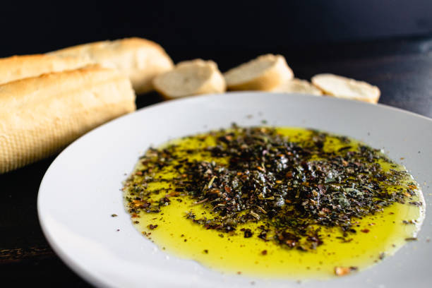 Extra virgin olive oil and green olives on a white wooden background with a copy space