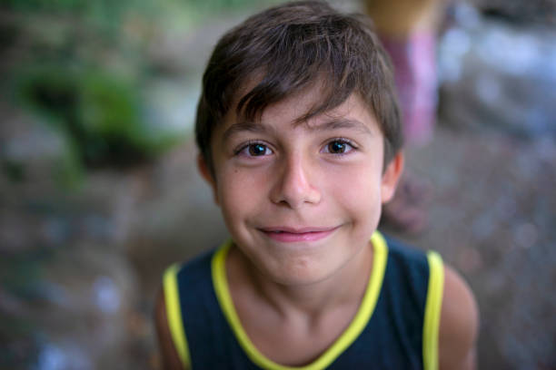 피크닉 지역에서 웃고있는 카메라를 바라보는 초등학교 소년. - fun child brown hair human age 뉴스 사진 이미지