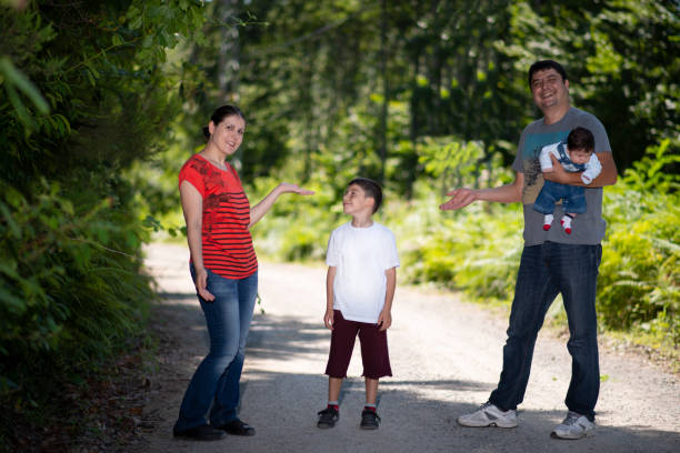 istock Parents and their two sons posing fun for the camera in lush nature. 1330447782
