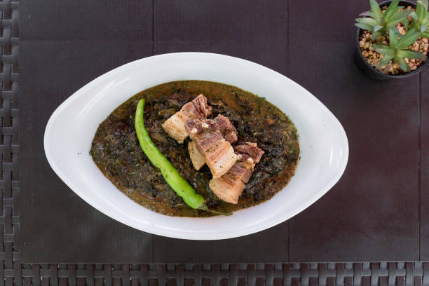 Laing topped with lechon kawali bits and Siling haba. A traditional Filipino delicacy also known as Pinangat. At an al fresco Philippine restaurant