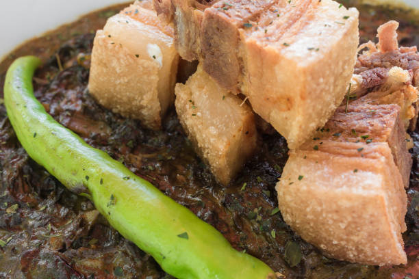 Laing topped with lechon kawali bits and Siling haba. A traditional Filipino delicacy also known as Pinangat. At an al fresco Philippine restaurant