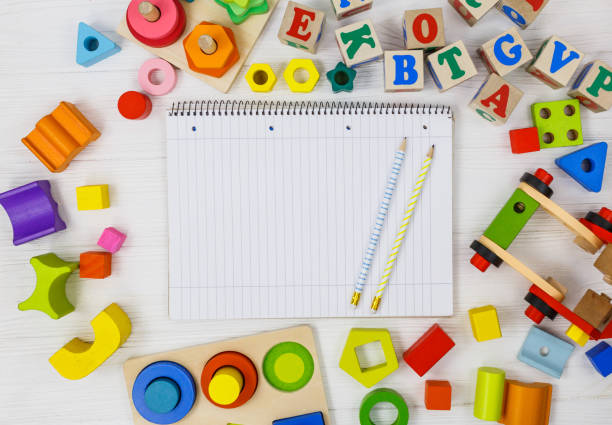 istock Open notepad, pencils, multicolored blocks on white wooden table. Back to school, education concept 1330458578