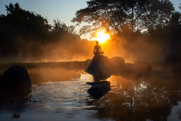 silhouette of a beautiful yoga woman in the morning at the hot spring park - spiritualiteit stockfoto's en -beelden