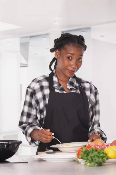 istock Smiling afro american woman whisking an egg: Cooking concept 1330480573
