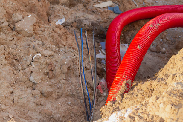 istock Laying an insulating plastic pipe with an electric cable underground during the construction of a house 1330485013