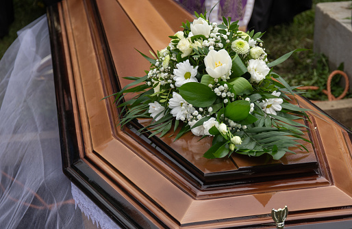 ramo de flores blancas en un ataúd en el cementerio photo