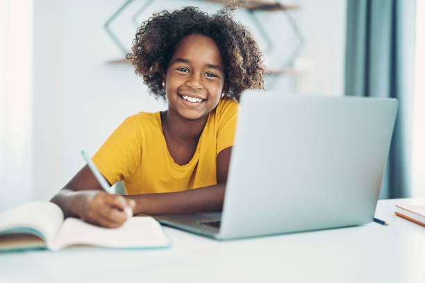 istock Smiling girls with laptop doing homework 1330497564