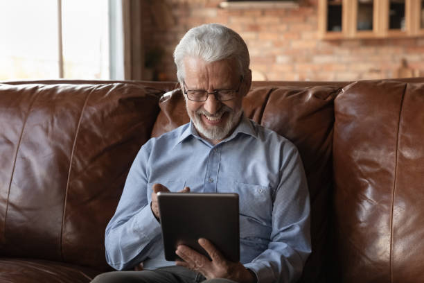 istock Happy elderly retired 70s man using online app on tablet 1330499324