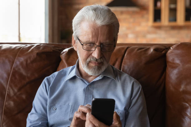 istock Focused elder 70s man using telemedicine app on smartphone 1330499334