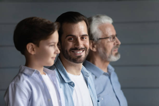 istock Happy young father standing in row with son and grandfather 1330499343