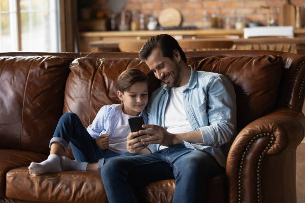 istock Happy kid and dad resting on on couch at home 1330499346