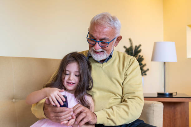istock Generation Gap. A Girl is Teaching Grandpa to Use a Tablet. 1330503073