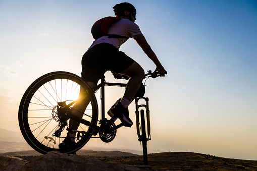Biker on mountain bike adventure against sunset