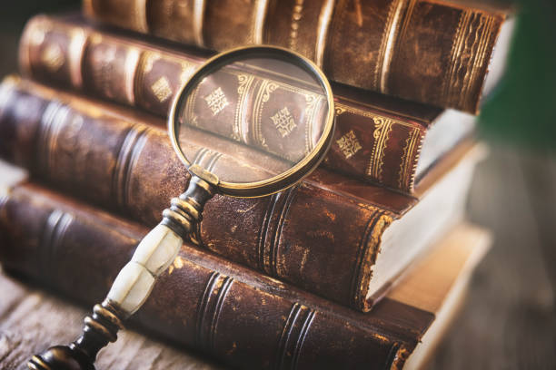 古い本と虫眼鏡 - magnifying glass book scrutiny research ストックフォトと画像