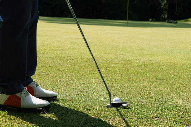 istock Golfer putting golf ball on the green golf 1330506504