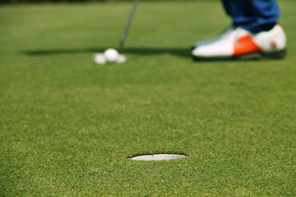 istock Golfer putting golf ball on the green golf 1330506589