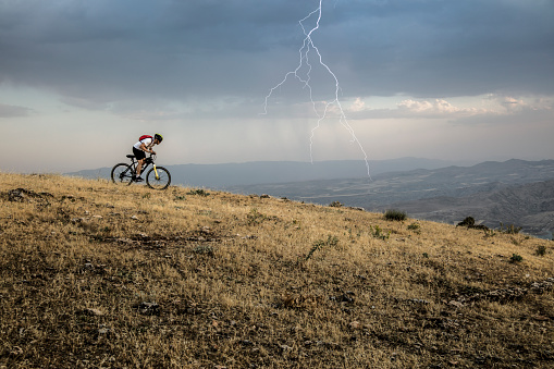 Biker on mountain bike adventure on a stormy day