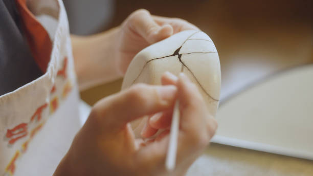 istock Woman repairing broken pottery. Kintsugi. 1330508920